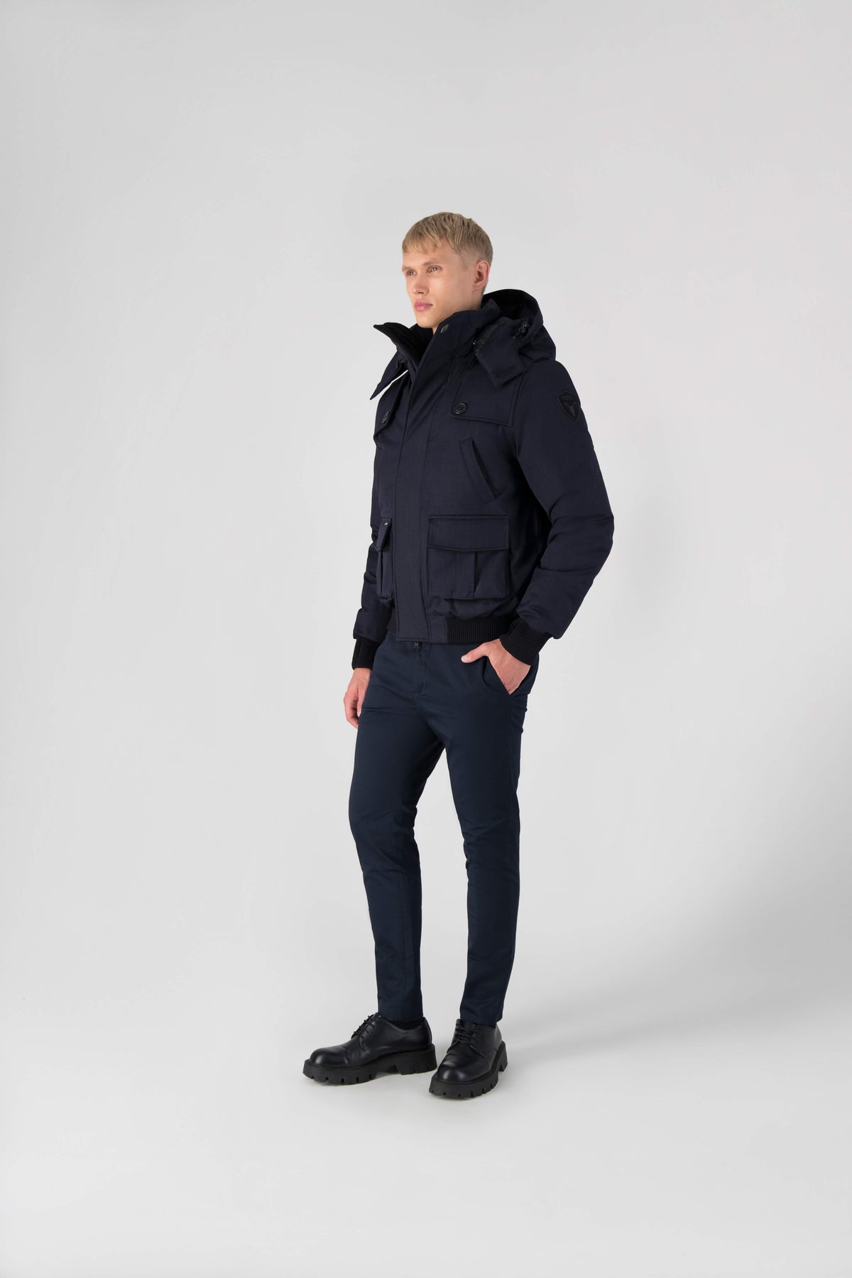 Men's down filled bomber that sits just above the hips with a completely removable hood that's windproof, waterproof, and breathable in Navy