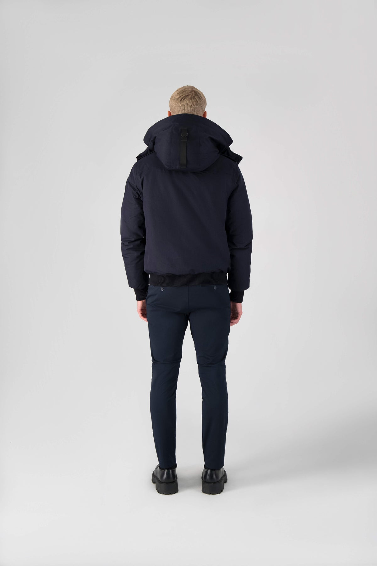 Men's down filled bomber that sits just above the hips with a completely removable hood that's windproof, waterproof, and breathable in Navy