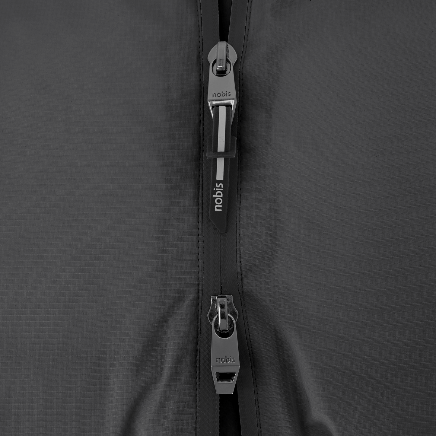 Dixon jacket in Black stretch ripstop fabric with DWR coating, large bellow pockets with magnetic flaps, hidden side-entry zipper pockets, and adjustable cuffs and hem for a tailored fit. Durable, weather-resistant, and versatile.