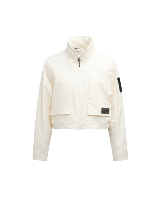 Epsie Women's Cropped Rain Jacket in Chalk crafted from premium recycled polyester ripstop with a DWR coating and taffeta nylon lining. Features a hidden packaway hood stored in the collar, two-way waterproof front zipper, seam-sealed construction, underarm zip ventilation, adjustable drawcord hem, zippered waist patch pockets, and an interior chest pocket for secure storage. Machine washable. Designed in Canada. + Chalk