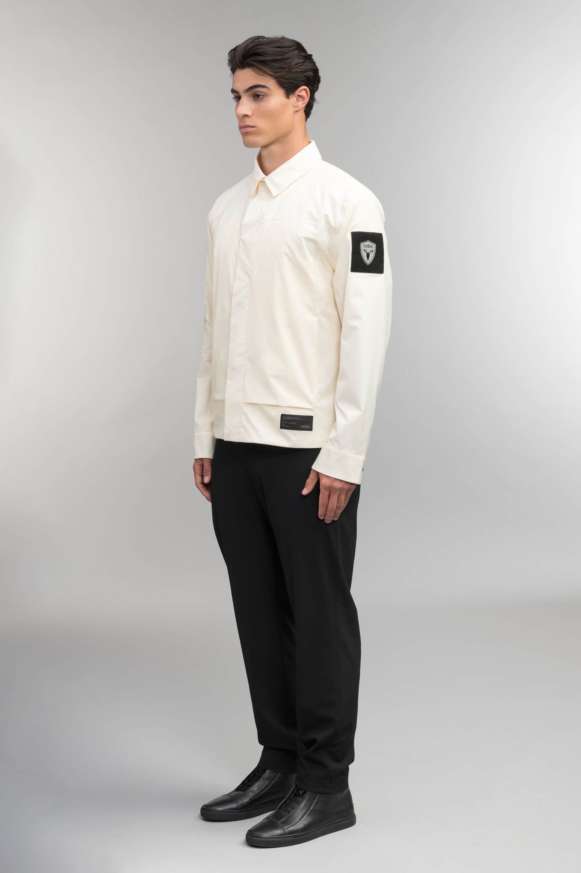 Farson Men's Waterproof Overshirt in Wheat made from premium recycled polyester ripstop with a DWR coating. Features a concealed snap-button front placket, adjustable snap cuffs, invisible chest zip pocket, dual zippered waist pockets, pit zip ventilation, and seam-sealed construction for enhanced weather protection. Designed in Canada.