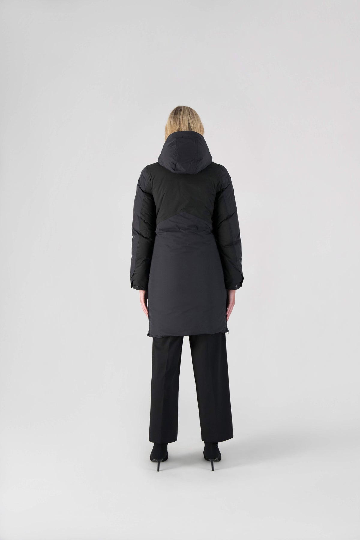 Inara Women's Performance Parka in knee length, premium 3-ply micro denier and stretch ripstop fabrication with DWR coating, Premium Canadian White Duck Down insulation, non-removable down-filled hood, centre front two-way zipper, large vertical zipper pockets along waist, zipper vents along bottom side hem, in Black