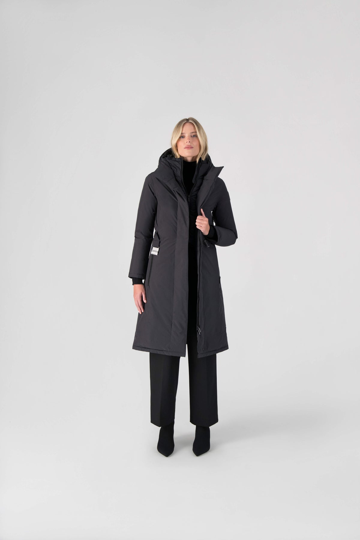 Long calf length hooded women's winter parka with an inner hip length closure, exterior hem length zipper and magnetic placket in Black