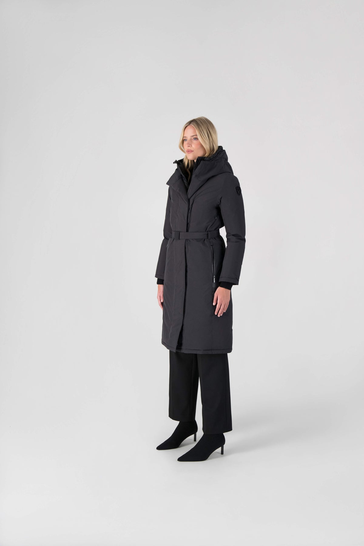 Long calf length hooded women's winter parka with an inner hip length closure, exterior hem length zipper and magnetic placket in Black