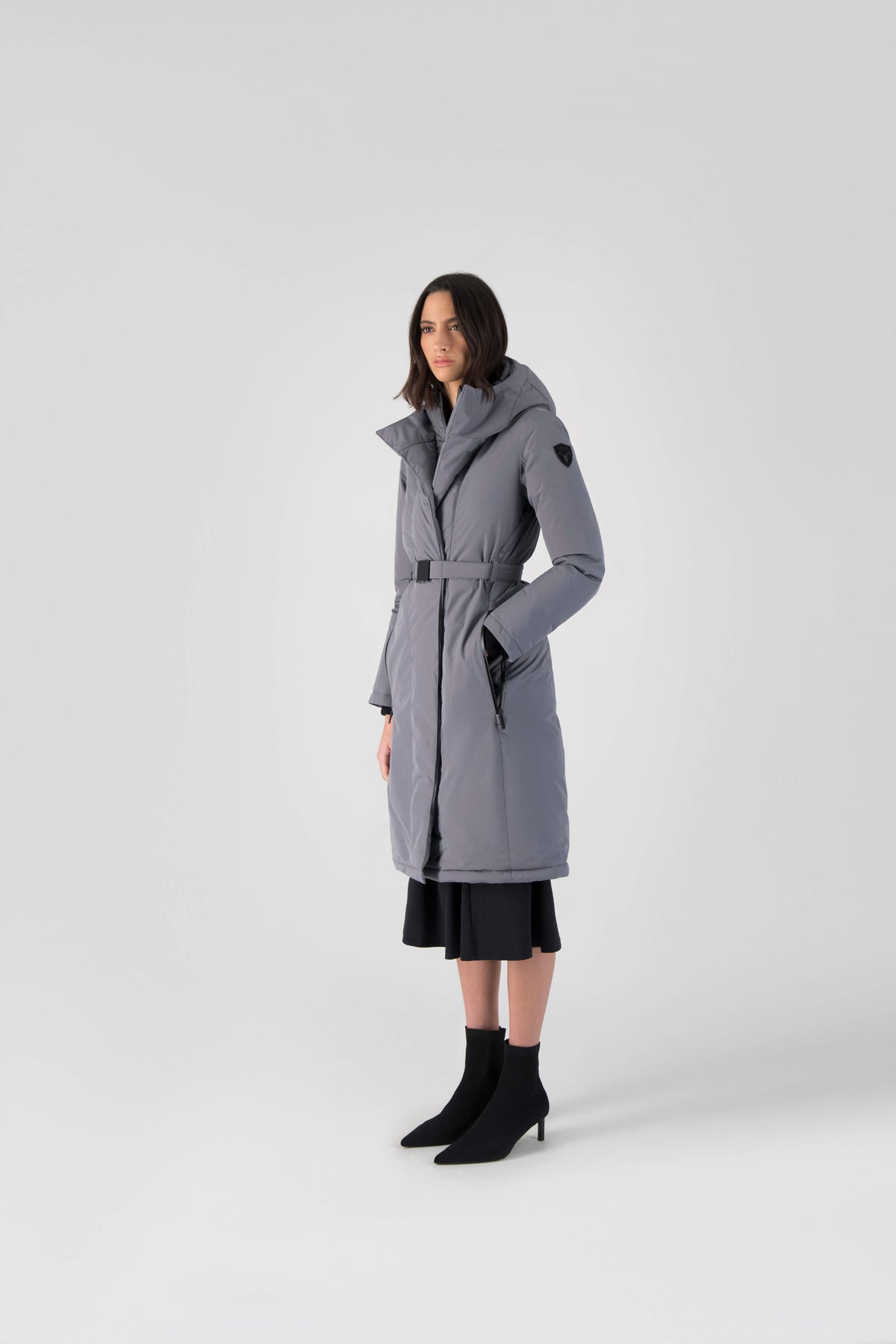Long calf length hooded women's winter parka with an inner hip length closure, exterior hem length zipper and magentic placket in Concrete