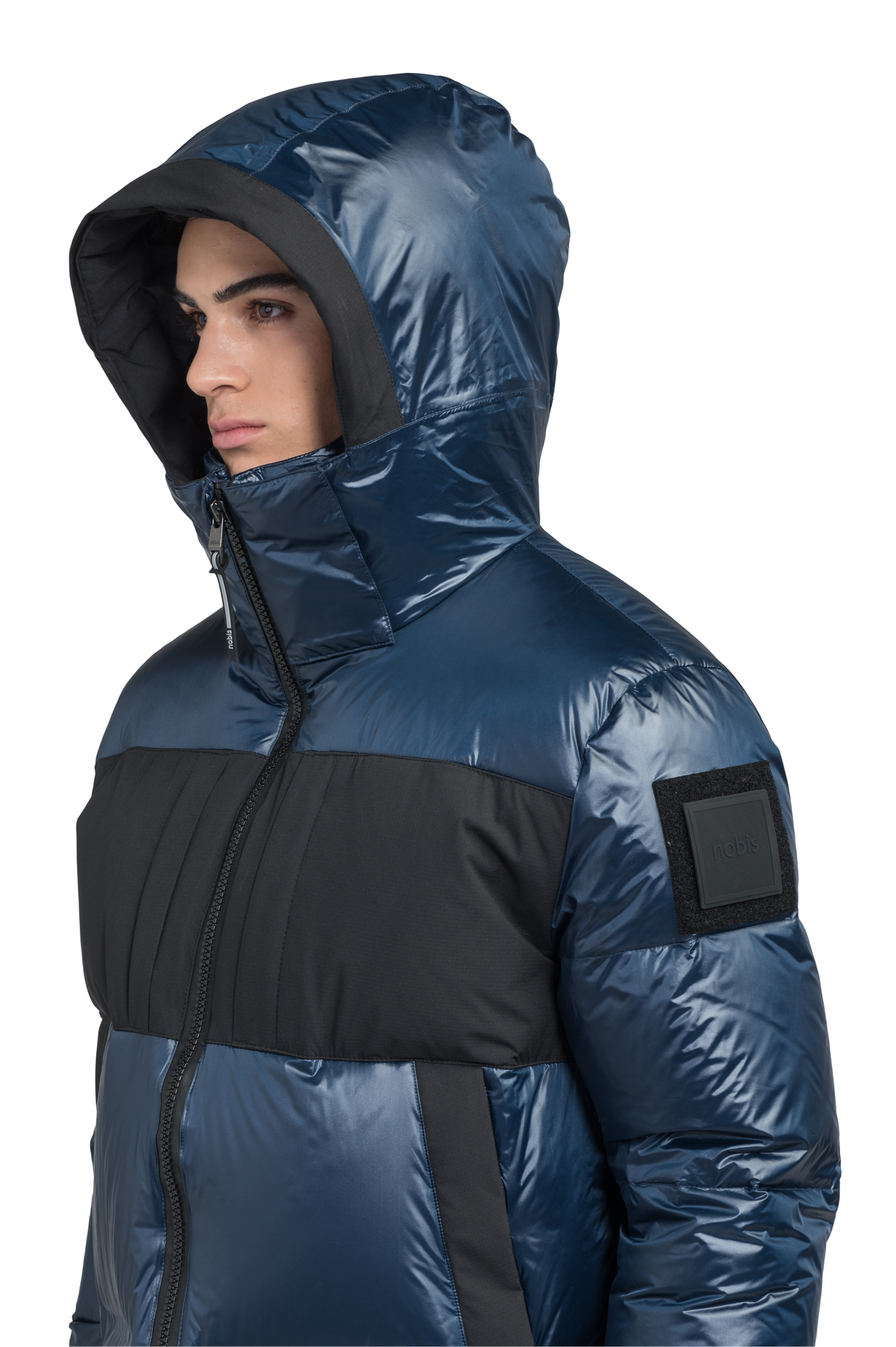 Neelix Men's Long Puffer Jacket in thigh length, premium cire technical nylon taffeta and stretch ripstop fabrication, Premium Canadian origin White Duck Down insulation, non-removable down-filled hood, two-way centre-front zipper, pit zipper vents, hidden chest zipper pockets, fleece-lined magnetic closure waist pockets, in Marine