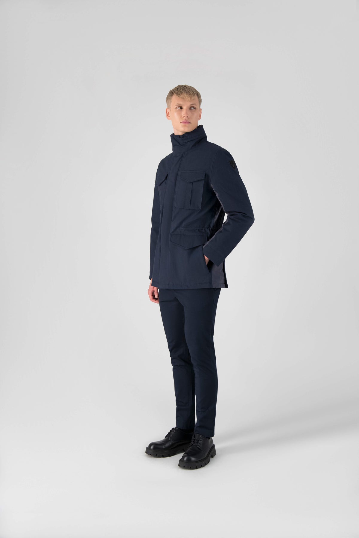 Pelican Men's Tailored Field Jacket in hip length, premium cotton blend and 3-ply micro denier fabrication, Premium Canadian origin White Duck Down insulation, tuck away, waterproof hood in premium cire technical nylon taffeta, two-way centre-front zipper with magnetic wind flap, pit zipper vents, magnetic closure chest and waist flap pockets, hidden adjustable waist drawcord, and action back detailing, in Navy
