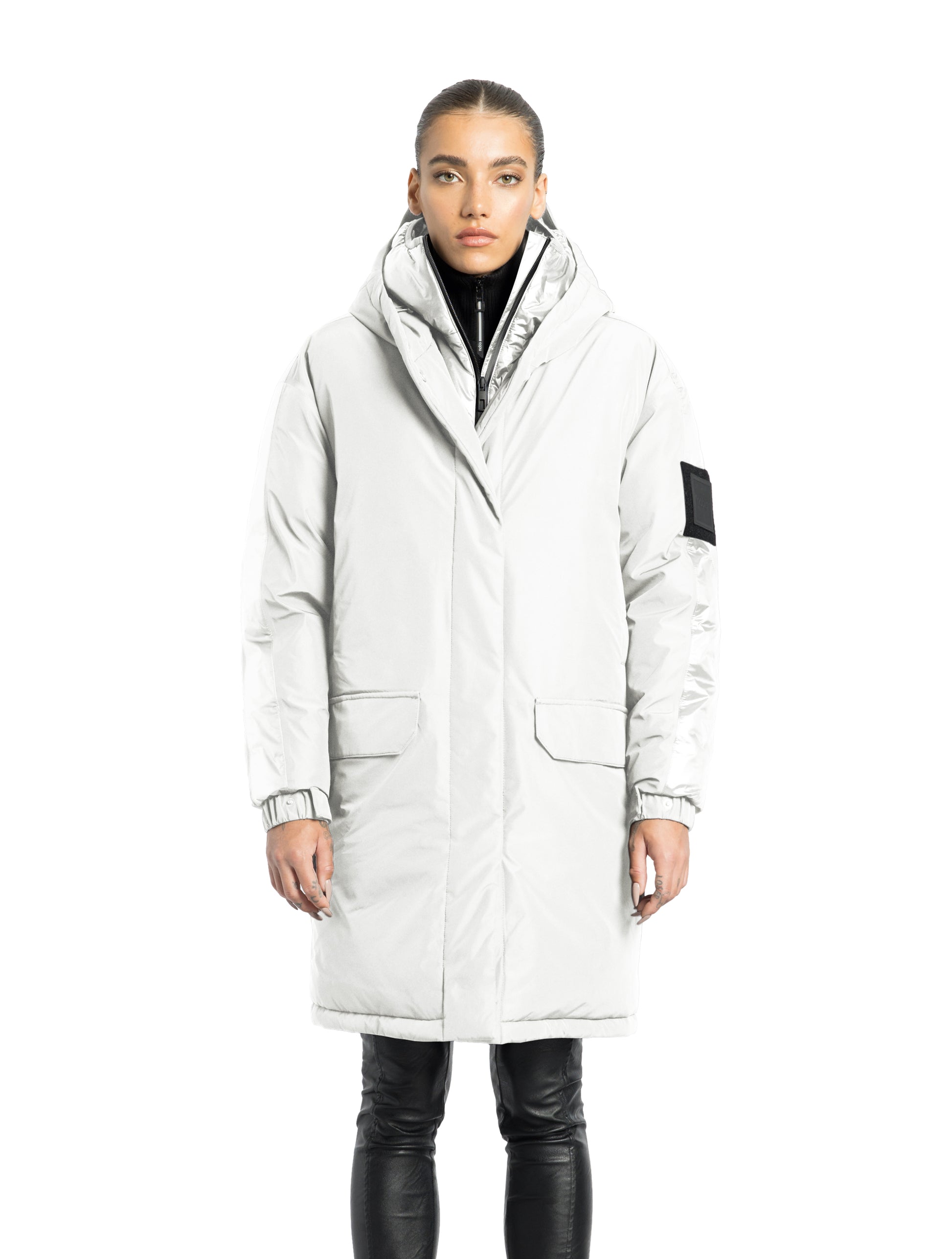 Slyn Women's Performance Parka in thigh length, premium 3-ply micro denier and cire technical nylon taffeta fabrication, Premium Canadian origin White Duck Down insulation, non-removable down-filled hood, inner hooded gilet, two-way centre-front zipper with magnetic closure wind flap, fleece-lined pockets at chest and waist, pit zipper vents, in Chalk