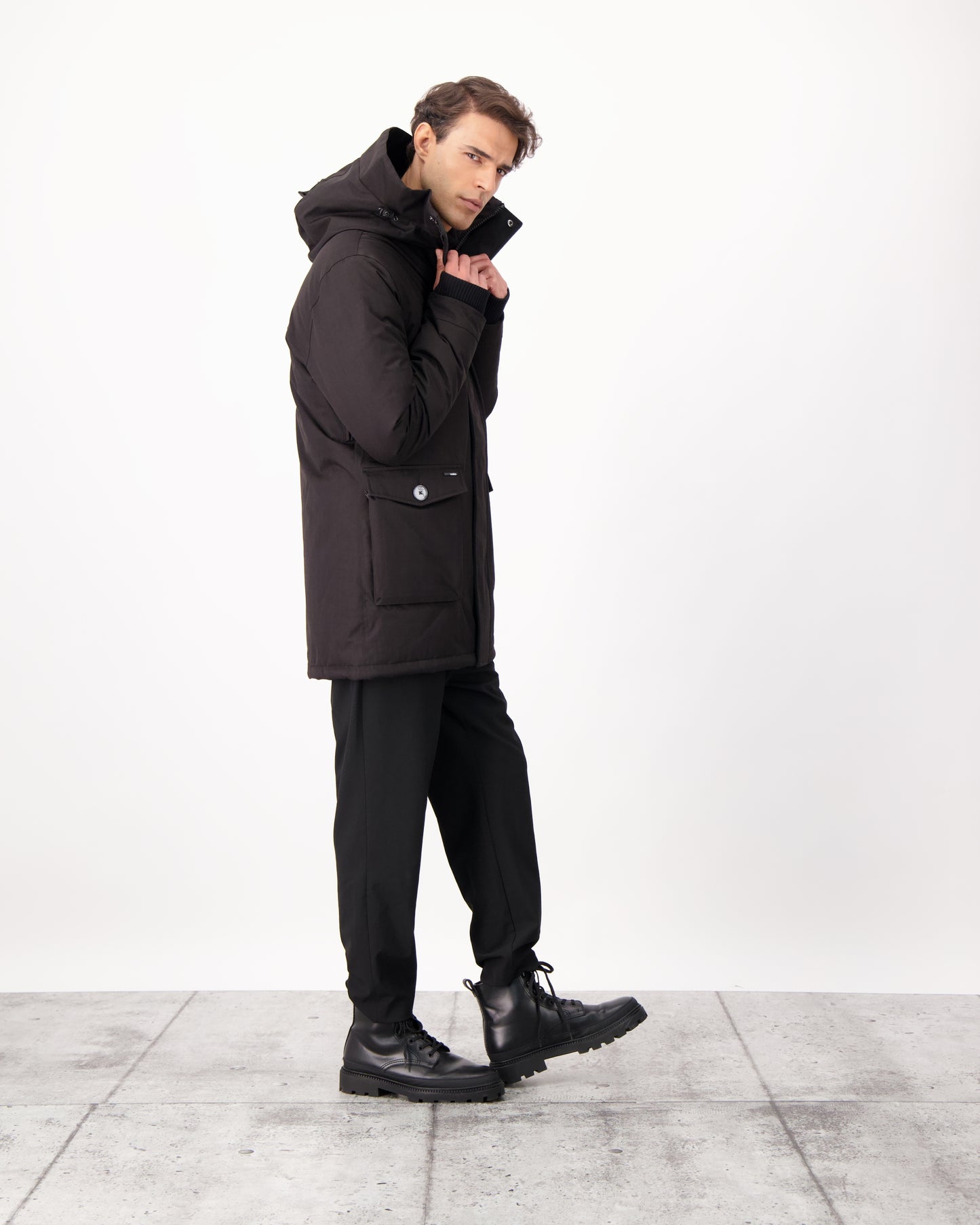 Yves Furless Men's Parka in thigh length, Canadian white duck down insulation, non-removable down-filled hood, flap pockets at waist, centre-front two-way zipper with magnetic wind flap, and elastic ribbed cuffs, in CH Black