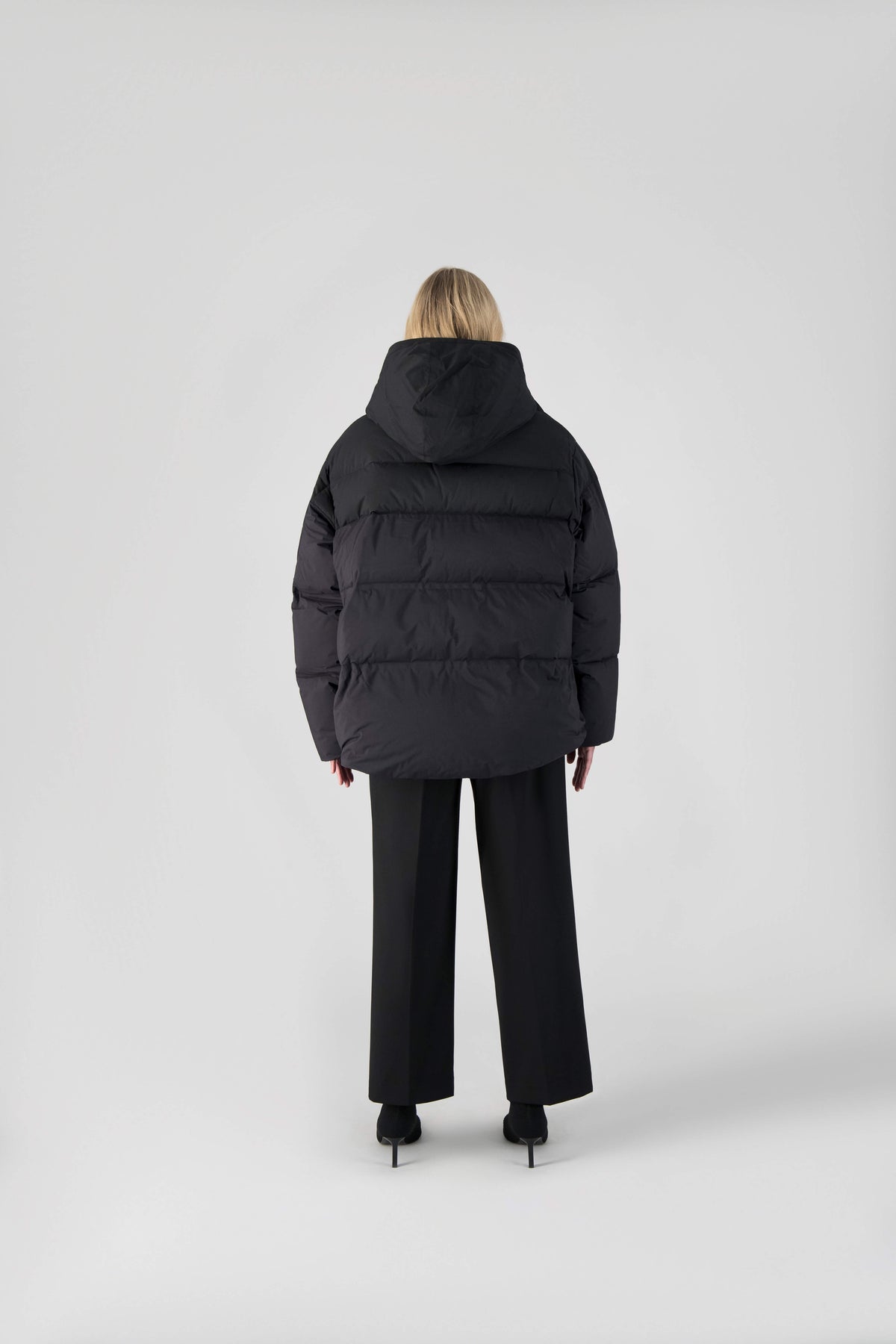 Una Ladies Performance Puffer in hip length, Technical Taffeta and Durable Stretch Ripstop fabrication, Premium Canadian White Duck Down insulation, removable down filled hood, centre front two-way zipper, and side-entry pockets at waist, in Black