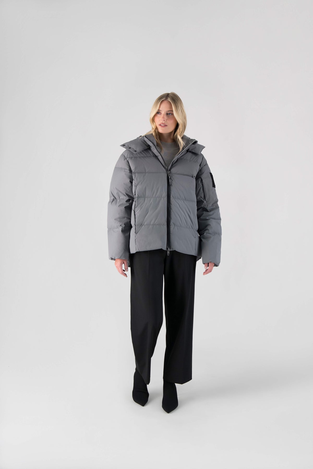 Una Ladies Performance Puffer in hip length, Technical Taffeta and Durable Stretch Ripstop fabrication, Premium Canadian White Duck Down insulation, removable down filled hood, centre front two-way zipper, and side-entry pockets at waist, in Concrete
