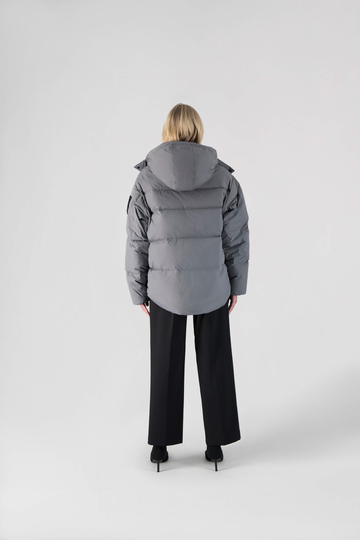 Una Ladies Performance Puffer in hip length, Technical Taffeta and Durable Stretch Ripstop fabrication, Premium Canadian White Duck Down insulation, removable down filled hood, centre front two-way zipper, and side-entry pockets at waist, in Concrete