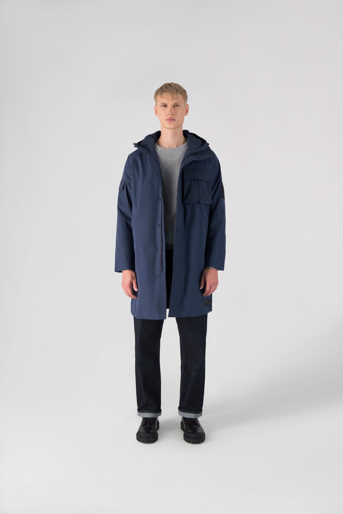 Wylder Men's Performance Rain Jacket in knee length, premium 3-ply Micro Denier and stretch ripstop fabrication, non-removable hood with reflective piping and adjustable draw cord, split utility chest pocket with magnetic flap closure, single welt pockets with magnetic closure at waist, back yoke with mesh ventilation, snap button wind flap, two-way branded zipper at centre front, telescopic sleeves with elasticized cuffs, interior draw cord at waist, in Marine