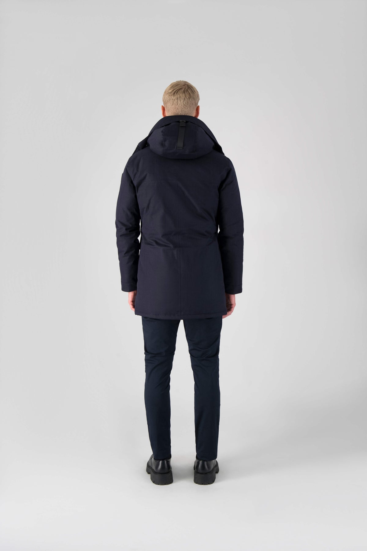 Men's slim fitting waist length parka with removable fur trim on the hood and two waist patch pockets in Navy