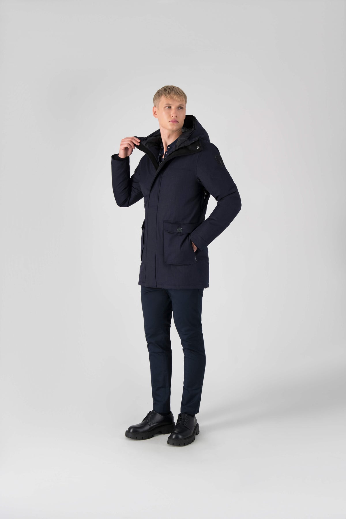 Men's slim fitting waist length parka with removable fur trim on the hood and two waist patch pockets in Navy