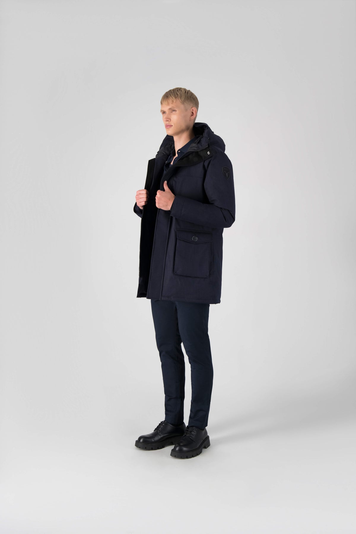 Men's slim fitting waist length parka with removable fur trim on the hood and two waist patch pockets in Navy