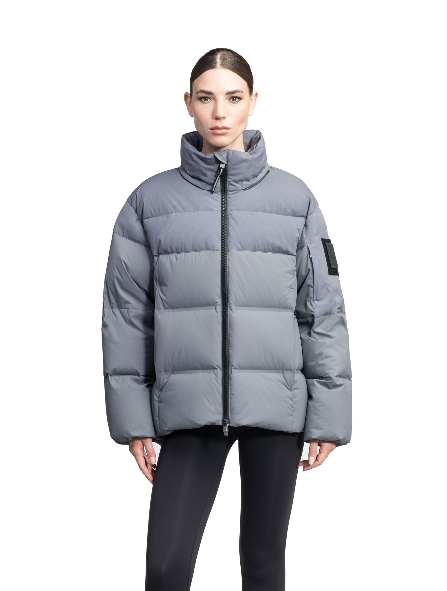 Una Ladies Performance Puffer in hip length, Technical Taffeta and Durable Stretch Ripstop fabrication, Premium Canadian White Duck Down insulation, removable down filled hood, centre front two-way zipper, and side-entry pockets at waist, in Concrete